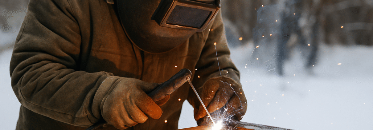 Soudeur renforçant une structure métallique en extérieur pour prévenir les effets du froid hivernal